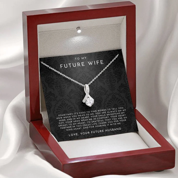 Gold necklace with a heart-shaped pendant on a decorative card for 'Future Wife' with romantic message.