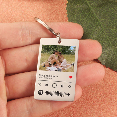 Keychain with a design of a couple at a picnic and Spotify interface.