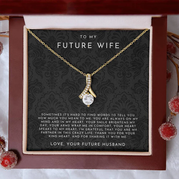 Gold necklace with a heart-shaped pendant on a decorative card for 'Future Wife' with romantic message.
